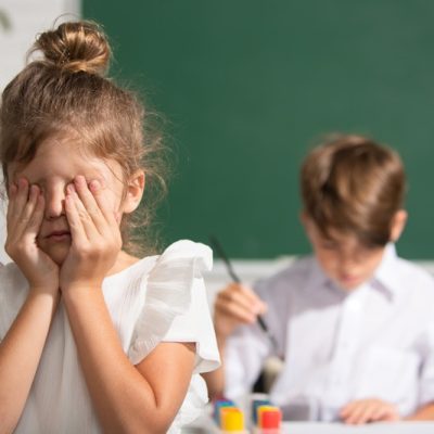 Huilend meisje met witte bloes wil niet meewerken aan de knutselopdracht